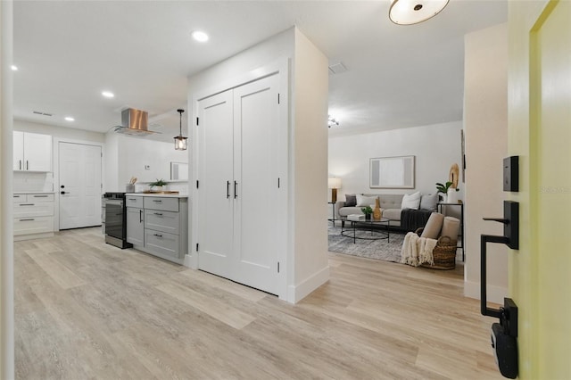 1470 Serpentine Dr S, Saint Petersburg, FL 33705 - kitchen featuring light wood finished floors, wall chimney exhaust hood, recessed lighting, baseboards, and open floor plan