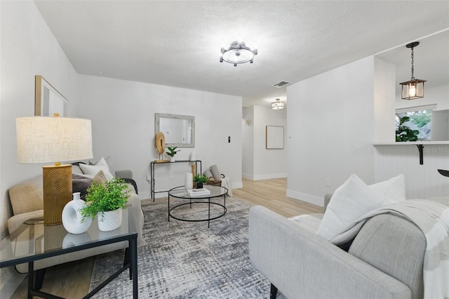 1470 Serpentine Dr S, Saint Petersburg, FL 33705 - living room with light wood-style floors, baseboards, and a textured ceiling