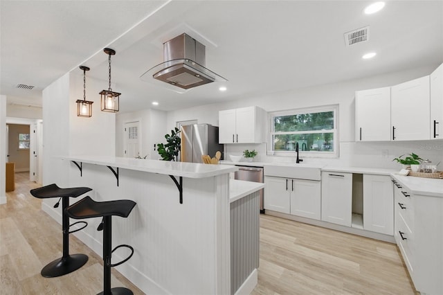 1470 Serpentine Dr S, Saint Petersburg, FL 33705 - kitchen with a sink, a breakfast bar area, stainless steel appliances, light wood finished floors, and recessed lighting