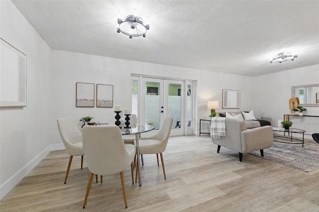 1470 Serpentine Dr S, Saint Petersburg, FL 33705 - dining room with french doors, light wood-type flooring, a textured ceiling, and baseboards