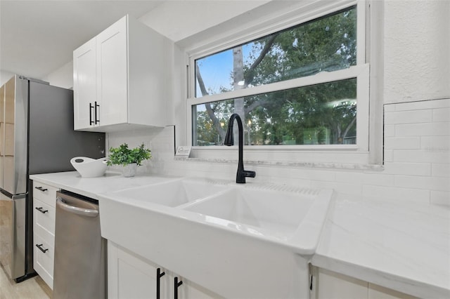 1470 Serpentine Dr S, Saint Petersburg, FL 33705 - kitchen featuring a sink, appliances with stainless steel finishes, white cabinetry, light countertops, and backsplash