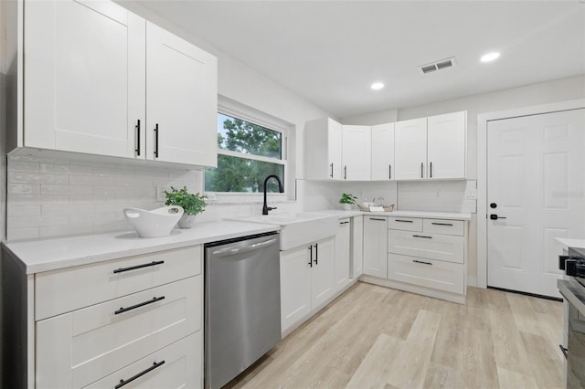 1470 Serpentine Dr S, Saint Petersburg, FL 33705 - kitchen featuring dishwasher, tasteful backsplash, a sink, light wood-style floors, and white cabinetry