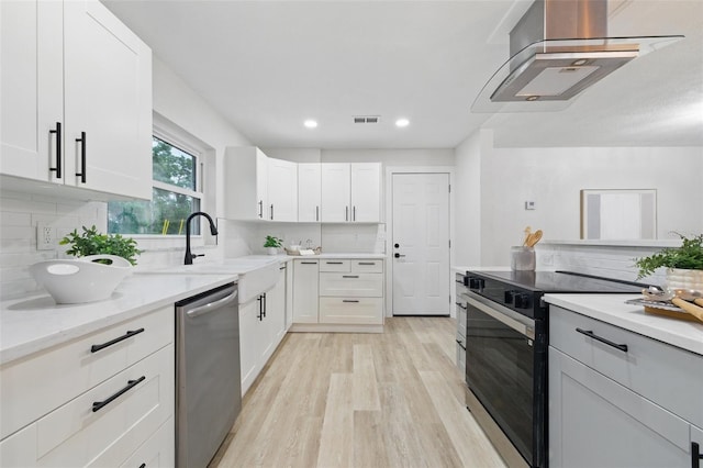 1470 Serpentine Dr S, Saint Petersburg, FL 33705 - kitchen featuring black range with electric stovetop, stainless steel dishwasher, wall chimney range hood, light wood finished floors, and decorative backsplash