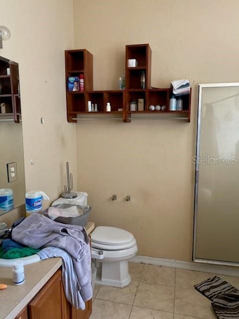 1720 SW Cameo Blvd, Port St Lucie, FL 34953 - bathroom featuring a stall shower, tile patterned floors, toilet, and baseboards