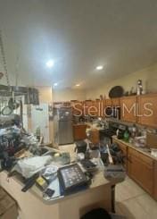 1720 SW Cameo Blvd, Port St Lucie, FL 34953 - kitchen featuring brown cabinets and light tile patterned flooring