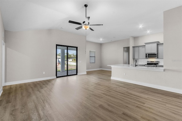 2414 Hiers Rd, Dover, FL 33527 - unfurnished living room with wood finished floors, a ceiling fan, vaulted ceiling, and recessed lighting