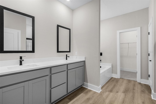 2414 Hiers Rd, Dover, FL 33527 - full bath featuring wood finished floors, double vanity, a bath, and a spacious closet