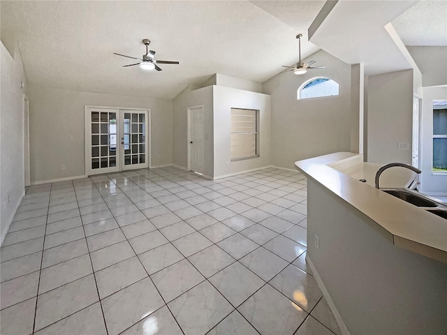 8812 Bayaud Dr, Tampa, FL 33626 - unfurnished living room with a ceiling fan, vaulted ceiling, a sink, french doors, and baseboards