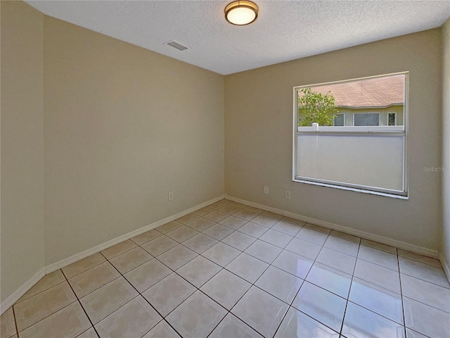 8812 Bayaud Dr, Tampa, FL 33626 - spare room with a textured ceiling, light tile patterned flooring, and baseboards