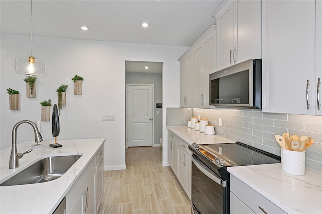 3424 Timber Crossing Ave, Brandon, FL 33511 - kitchen with stainless steel appliances, a sink, tasteful backsplash, light wood-style floors, and baseboards