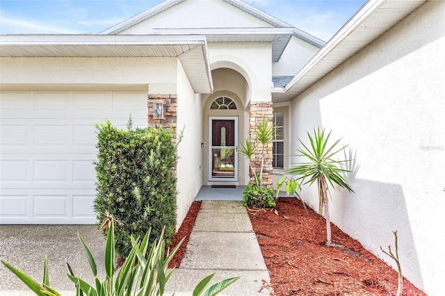 12746 Standbridge Dr, Riverview, FL 33579 - property entrance featuring a garage, stucco siding, and stone siding