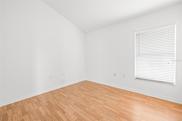 12746 Standbridge Dr, Riverview, FL 33579 - empty room with light wood finished floors, vaulted ceiling, and baseboards