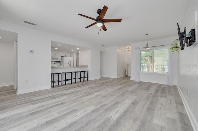 3595 41st Ln S Unit L, Saint Petersburg, FL 33711 - unfurnished living room with a ceiling fan, light wood-style flooring, baseboards, a sink, and recessed lighting