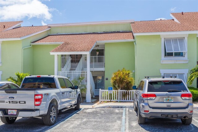 3595 41st Ln S Unit L, Saint Petersburg, FL 33711 - view of front facade with a shingled roof, uncovered parking, and stucco siding