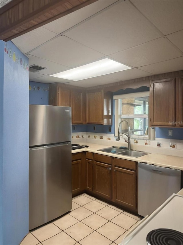 2220 Woods Trl, Lakeland, FL 33809 - kitchen with stainless steel appliances, a sink, light countertops, and light tile patterned floors