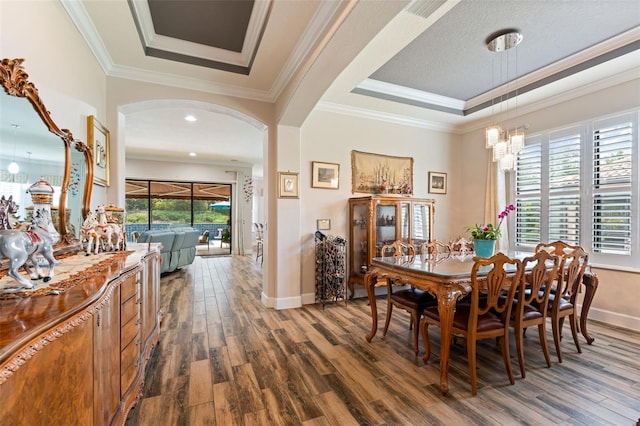 12672 Fontana Loop, Bradenton, FL 34211 - dining room featuring dark wood finished floors, a chandelier, baseboards, arched walkways, and crown molding