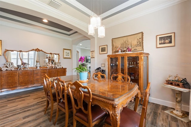 12672 Fontana Loop, Bradenton, FL 34211 - dining area featuring dark wood-style floors, arched walkways, ornamental molding, baseboards, and a raised ceiling