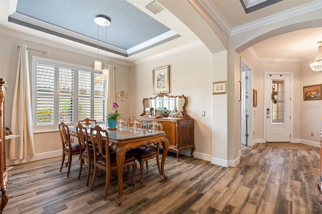 12672 Fontana Loop, Bradenton, FL 34211 - dining area featuring arched walkways, wood finished floors, a chandelier, crown molding, and a tray ceiling