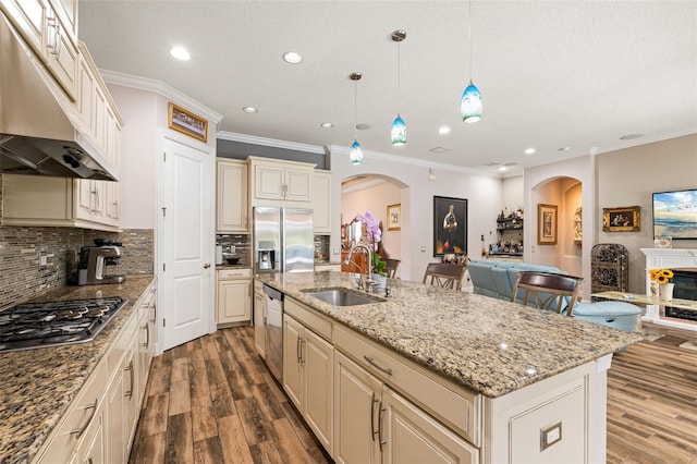 12672 Fontana Loop, Bradenton, FL 34211 - kitchen featuring a sink, under cabinet range hood, arched walkways, appliances with stainless steel finishes, and cream cabinetry