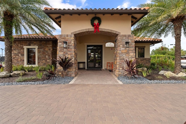 12672 Fontana Loop, Bradenton, FL 34211 - view of exterior entry with french doors, stucco siding, stone siding, and a tile roof