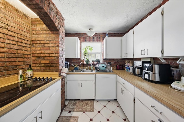 11285 8th St E, Treasure Island, FL 33706 - kitchen featuring a sink, dishwasher, brick wall, white cabinetry, and light flooring