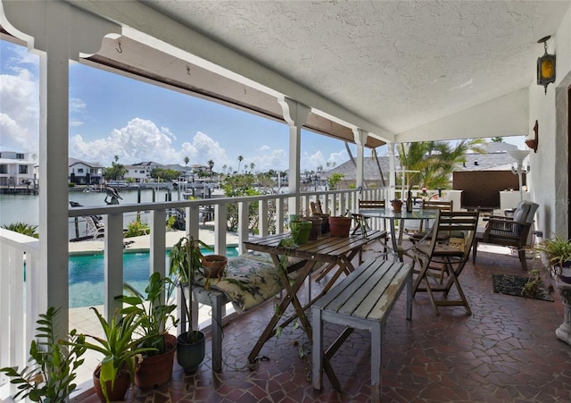 11285 8th St E, Treasure Island, FL 33706 - view of patio / terrace with a water view, an outdoor pool, and outdoor dining space