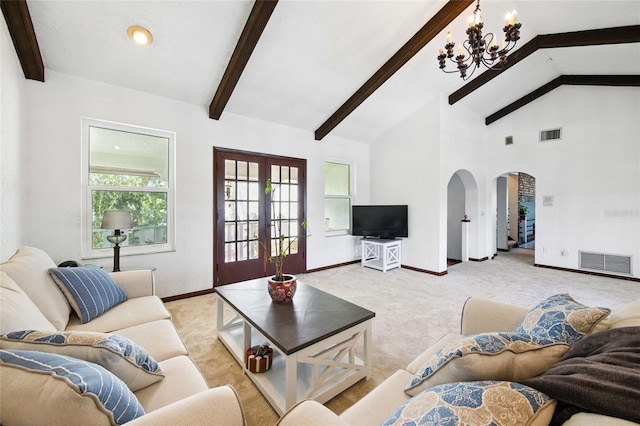 11285 8th St E, Treasure Island, FL 33706 - living room with a chandelier, arched walkways, beamed ceiling, light carpet, and french doors