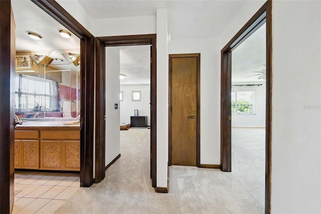 11285 8th St E, Treasure Island, FL 33706 - corridor with light colored carpet, baseboards, and a sink