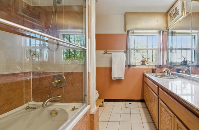 11285 8th St E, Treasure Island, FL 33706 - full bathroom with toilet, tile patterned floors, vanity, baseboards, and combined bath / shower with glass door