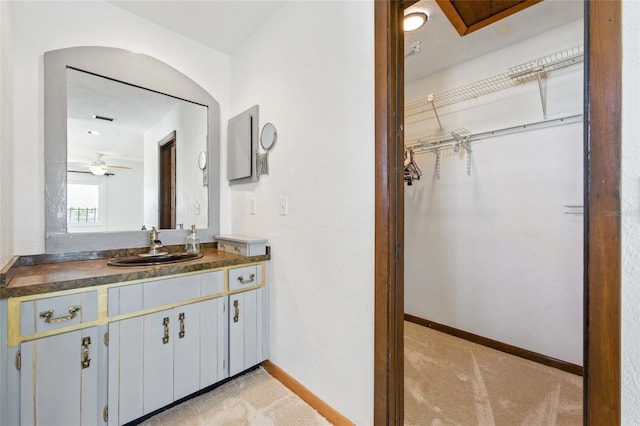 11285 8th St E, Treasure Island, FL 33706 - bathroom featuring vanity, a spacious closet, baseboards, and a ceiling fan