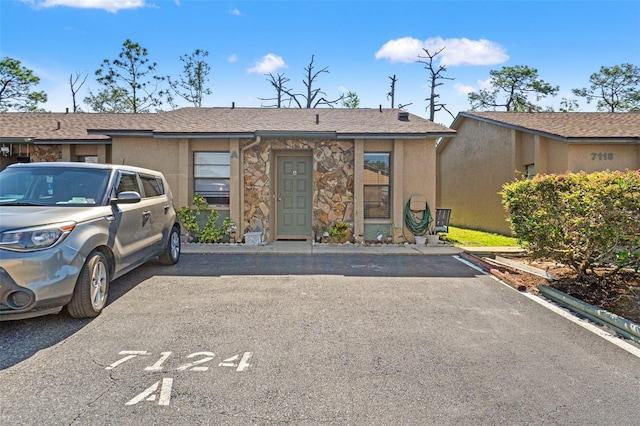 7124 Barclay Ave Unit A, Spring Hill, FL 34609 - view of front of property featuring uncovered parking, stone siding, and stucco siding