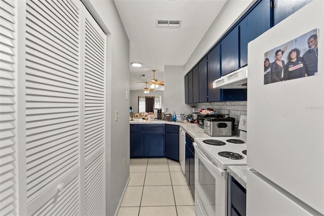 7124 Barclay Ave Unit A, Spring Hill, FL 34609 - kitchen featuring white appliances, under cabinet range hood, blue cabinets, light countertops, and a textured ceiling