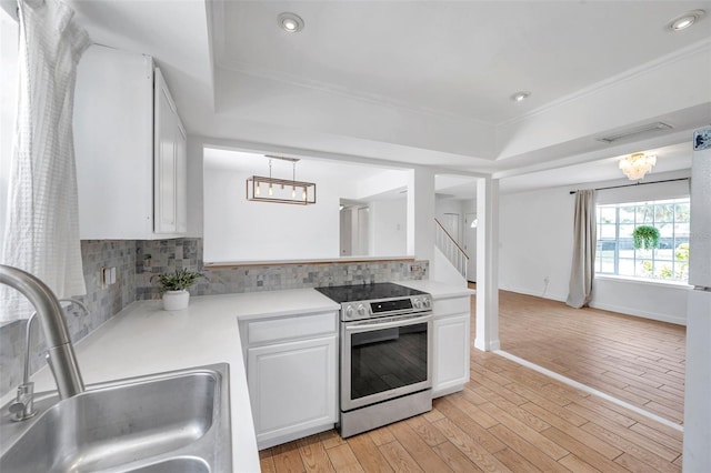 3865 Gatewood Dr, Sarasota, FL 34232 - kitchen with stainless steel range with electric stovetop, a sink, a raised ceiling, light countertops, and recessed lighting