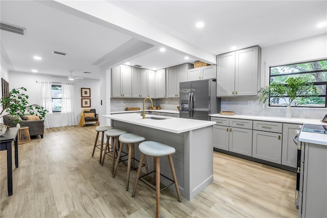 300 33rd Ave N, Saint Petersburg, FL 33704 - kitchen with gray cabinetry, refrigerator with ice dispenser, stainless steel electric stove, tasteful backsplash, and light countertops