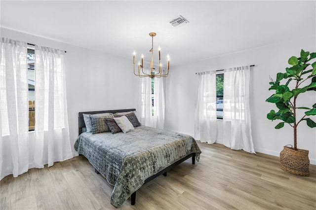300 33rd Ave N, Saint Petersburg, FL 33704 - bedroom with light wood-style flooring, a chandelier, and baseboards