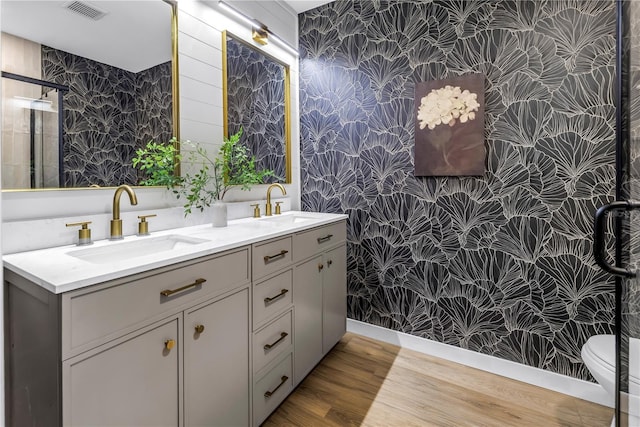 300 33rd Ave N, Saint Petersburg, FL 33704 - full bath with wallpapered walls, double vanity, wood finished floors, toilet, and a shower with door