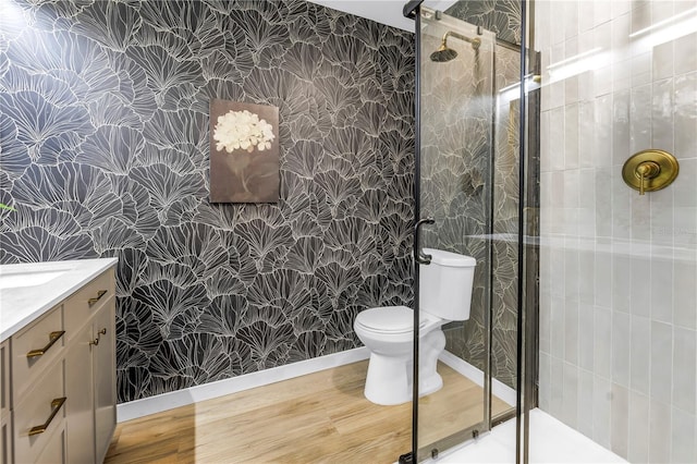 300 33rd Ave N, Saint Petersburg, FL 33704 - full bathroom featuring wallpapered walls, toilet, vanity, a stall shower, and wood finished floors
