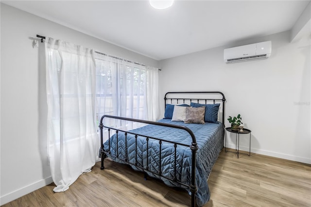 300 33rd Ave N, Saint Petersburg, FL 33704 - bedroom with a wall mounted AC, baseboards, and wood finished floors
