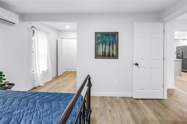 300 33rd Ave N, Saint Petersburg, FL 33704 - bedroom featuring stainless steel fridge, an AC wall unit, light wood-type flooring, baseboards, and recessed lighting