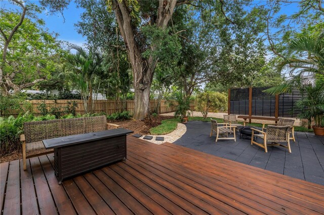 300 33rd Ave N, Saint Petersburg, FL 33704 - wooden terrace featuring a fenced backyard, an outdoor living space with a fire pit, and a patio