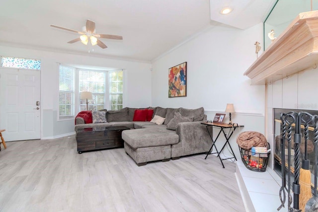 2648 Sabal Springs Dr Unit 2, Clearwater, FL 33761 - living area featuring crown molding, a tile fireplace, light wood finished floors, a ceiling fan, and baseboards