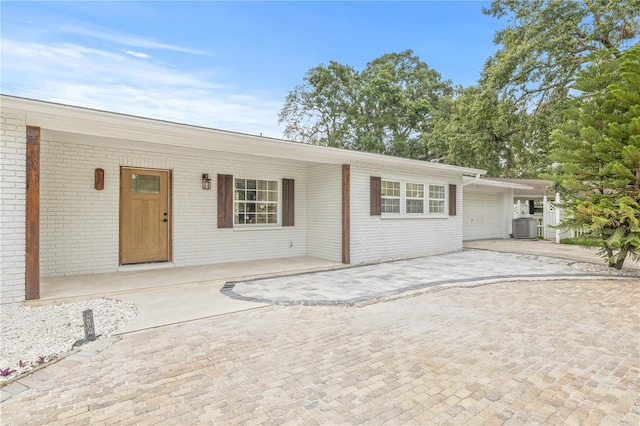2554 Lake Ellen Cir, Tampa, FL 33618 - view of front of property with covered porch, brick siding, a garage, and central air condition unit