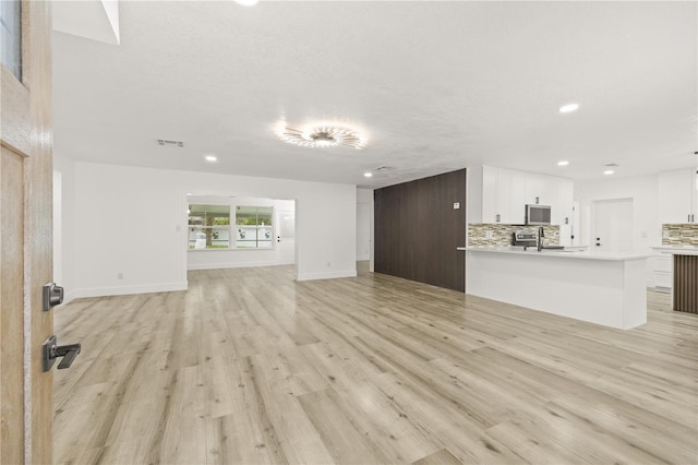 2554 Lake Ellen Cir, Tampa, FL 33618 - unfurnished living room with a sink, recessed lighting, light wood finished floors, and baseboards