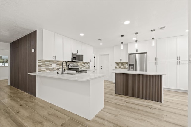 2554 Lake Ellen Cir, Tampa, FL 33618 - kitchen featuring stainless steel appliances, a sink, tasteful backsplash, a peninsula, and light wood-style flooring