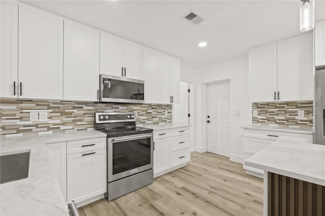 2554 Lake Ellen Cir, Tampa, FL 33618 - kitchen featuring appliances with stainless steel finishes, white cabinetry, decorative backsplash, recessed lighting, and light wood finished floors
