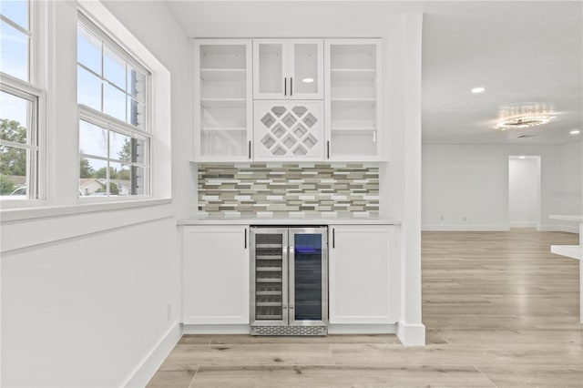 2554 Lake Ellen Cir, Tampa, FL 33618 - indoor dry bar with wine cooler, baseboards, decorative backsplash, light wood-type flooring, and recessed lighting