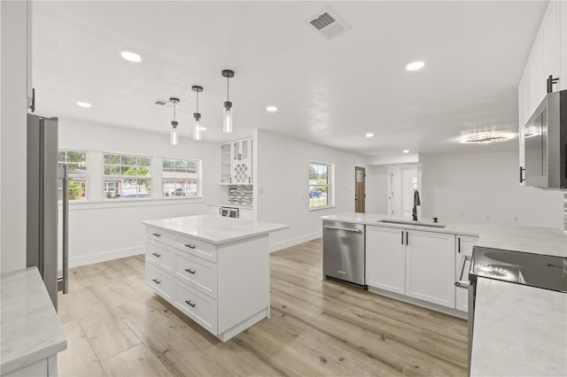 2554 Lake Ellen Cir, Tampa, FL 33618 - kitchen with stainless steel appliances, a sink, recessed lighting, white cabinetry, and light wood finished floors