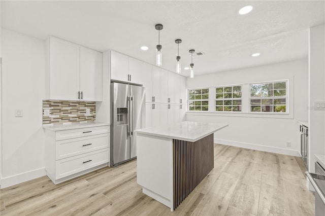 2554 Lake Ellen Cir, Tampa, FL 33618 - kitchen with stainless steel fridge, light wood-style flooring, white cabinets, light countertops, and recessed lighting