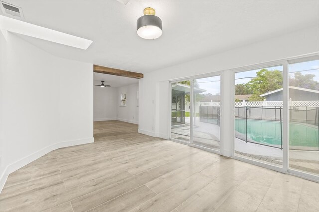 2554 Lake Ellen Cir, Tampa, FL 33618 - empty room with light wood-style flooring, baseboards, a ceiling fan, and a skylight