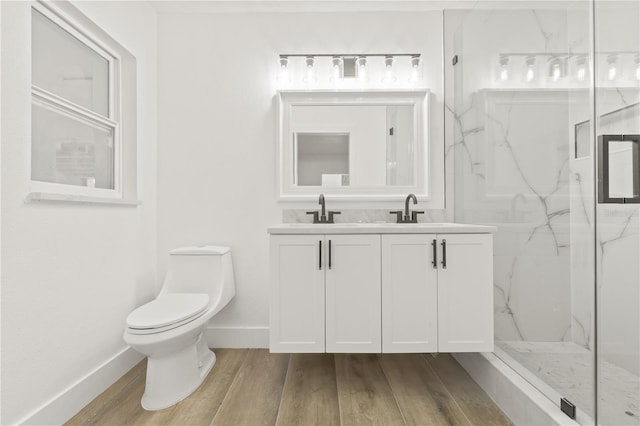 2554 Lake Ellen Cir, Tampa, FL 33618 - bathroom featuring a marble finish shower, double vanity, toilet, baseboards, and wood finished floors